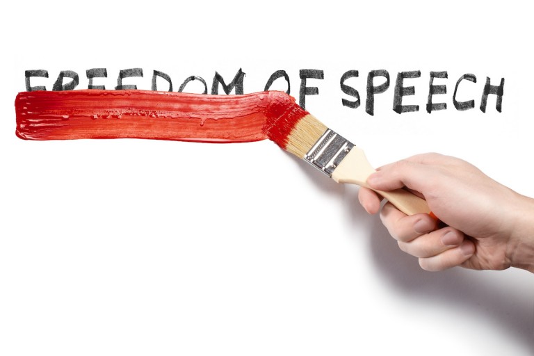 hand-painting-over-the-words-freedom-of-speech-using-a-red-brush